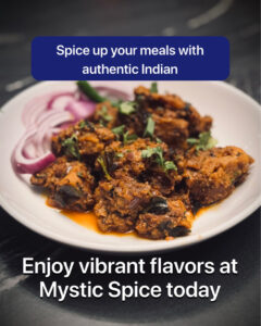 Plate of spiced Indian curry garnished with fresh cilantro and sliced red onions.